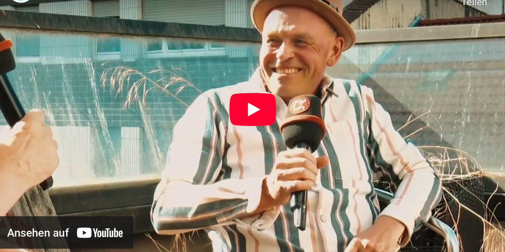 young man wearing shades and a hat with a beard, tattos and ear piercings